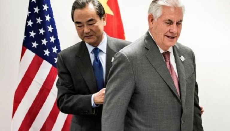 وزير الخارجية الأمريكي ريكس تيلرسون ومن خلفه نظيره الصيني وانغ يي