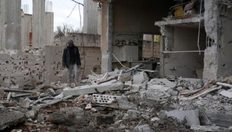 رجل يقف على أطلال منزل مدمر في سوريا