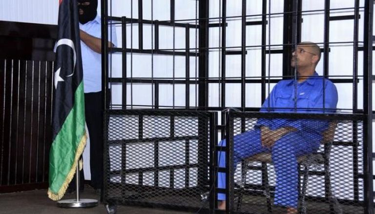سيف الإسلام القذافي لدى حضوره جلسة استماع خلف القضبان في محكمة بالزنتان