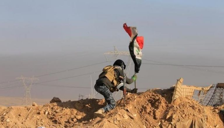جندي عراقي يرفع علم بلاده في جنوب الموصل (رويترز)