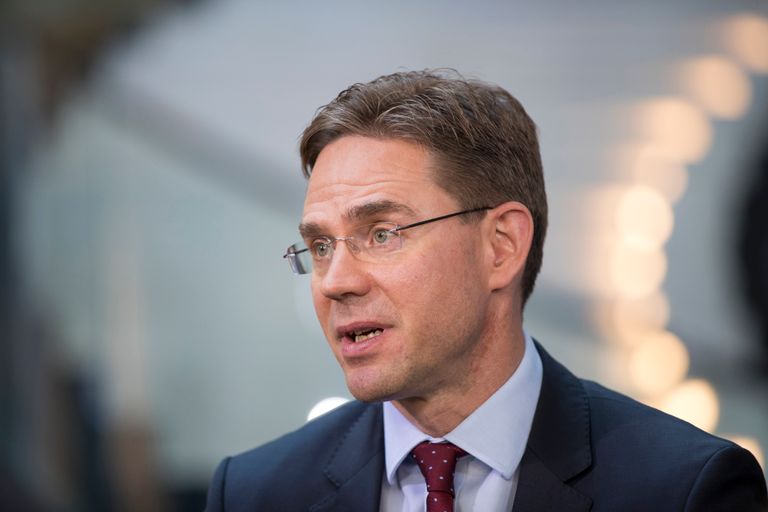 نائب رئيس المفوضية الأوروبية جيركي كاتاينين علم الاتحاد الأوروبي وبجانبه علم الولايات المتحدة (رويترز)