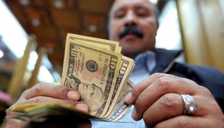 مواطن مصري يبيع الدولار في أحد الصرافات 