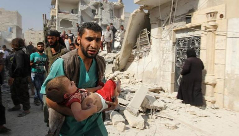 عامل إغاثة ينقذ طفلا سوريا مصابا