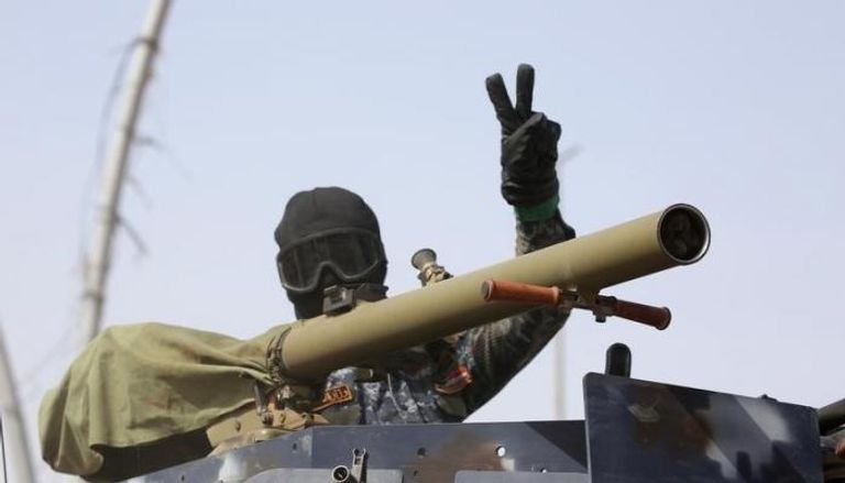 ضابط بالشرطة العراقية يلوح بعلامة النصر في الموصل (رويترز)