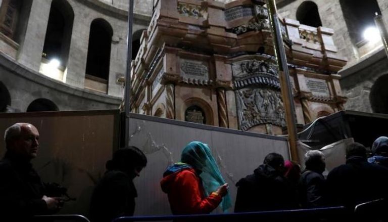 زوار بجوار سياج "قبر المسيح" (رويترز)