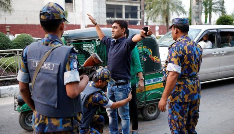 شرطة بنجلادش تفتش أحد الأشخاص قرب مطار دكا 