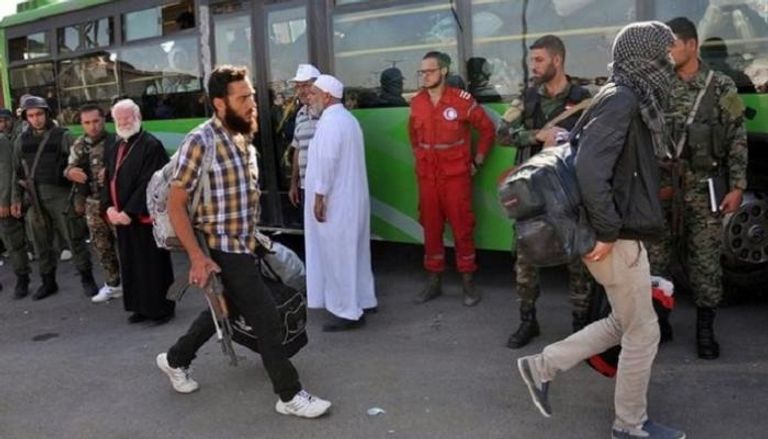 مقـاتلون من المعارضة السورية يغادرون حيّا في حمص (رويترز)