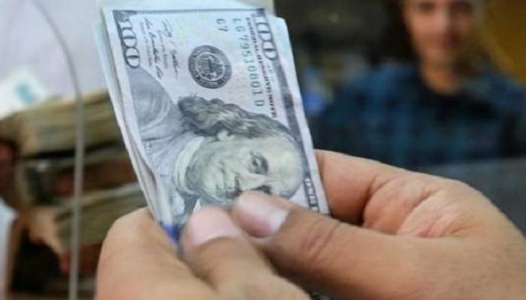 موظف يعد أوراق نقد من الدولار بمكتب صرافة بالقاهرة  رويترز.