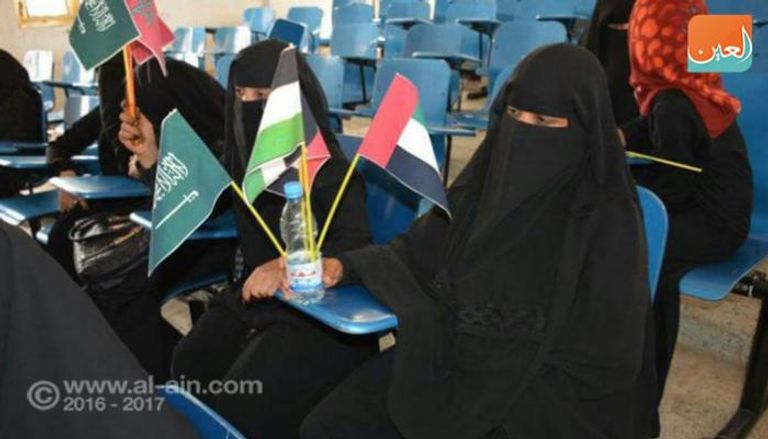 يمنية ترفع أعلام بعض الدول المشاركة في التحالف
