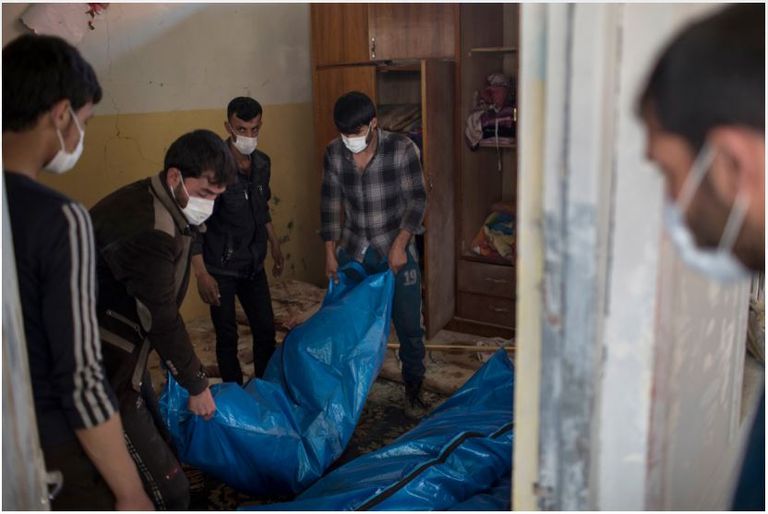 عراقيون بجوار منزل مدمر في الموصل الجديدة