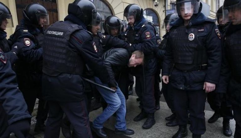 رجال شرطة يلقون القبض على رجل خلال احتجاج في موسكو