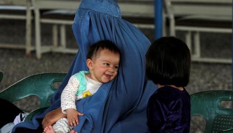 لاجئة أفغانية تنتظر مع طفليها ترحيلها إلى أفغانستان