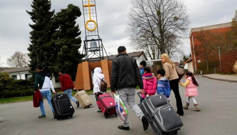 لاجئون سوريون لدى وصولهم إلى مخيم للاجئين والمهاجرين في ألمانيا