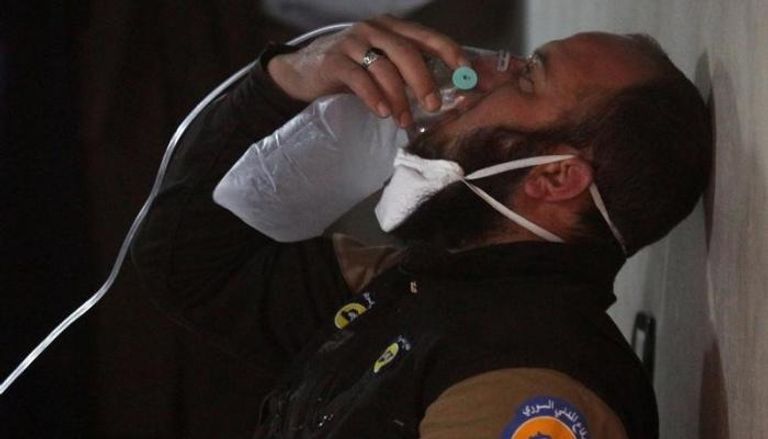 أحد عمال الإنقاذ يتنفس من خلال جهاز صناعي في إدلب