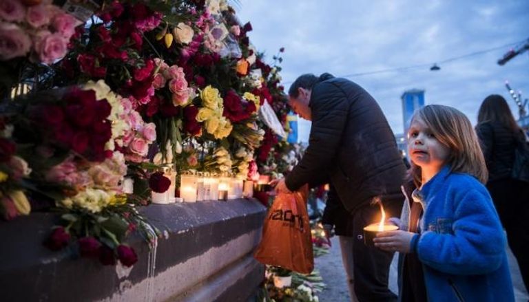 سويديون يضعون باقات الورود في موقع الحادث (الفرنسية)