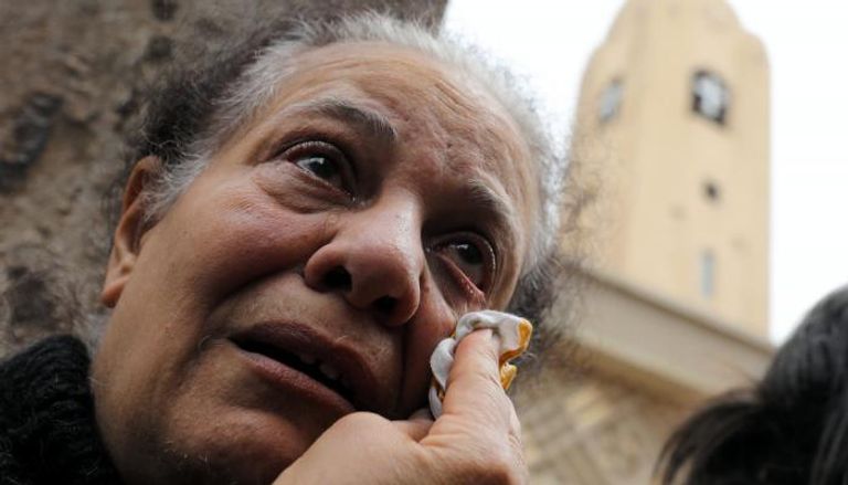 سيدة تبكي أمام كنيسة مار جرجس بطنطا بعد التفجير الإرهابي - رويترز