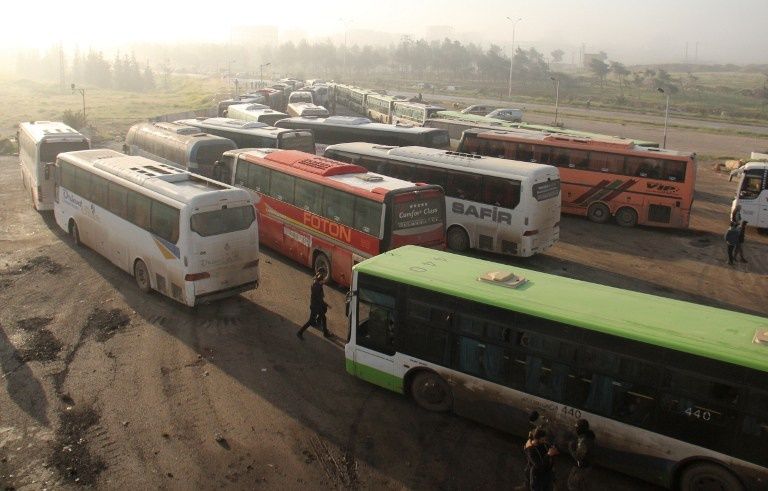 عناصر من المعارضة المسلحة خلال رحيلها من فوعة وكفريا (الفرنسية)
