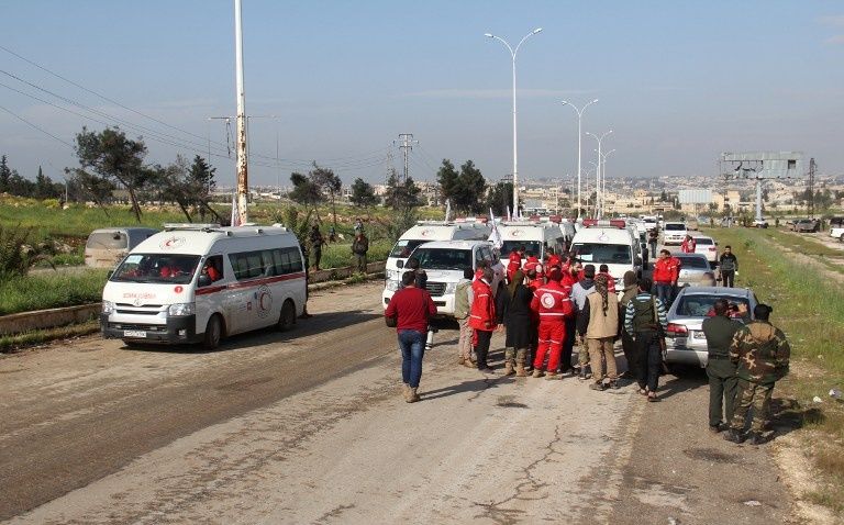 عناصر من المعارضة المسلحة خلال رحيلها من فوعة وكفريا (الفرنسية)