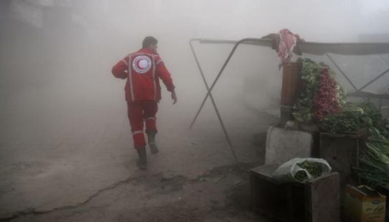 مسعف يحمل جثة طفلة قتلت بالغاز في خان شيخون