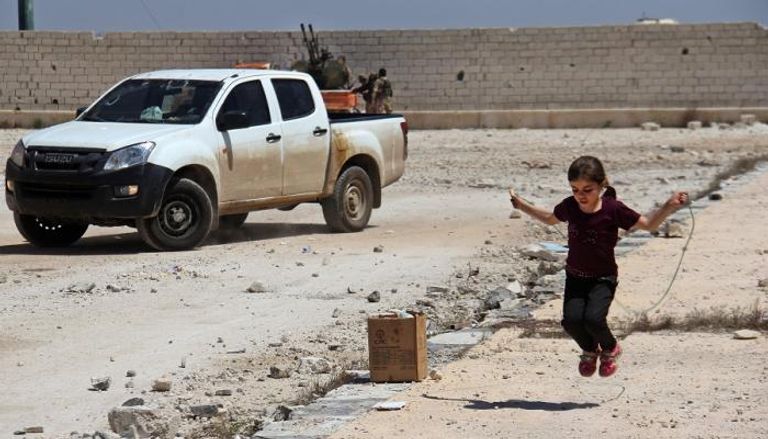 طفلة سورية تلهو أمام السلاح بسوريا 