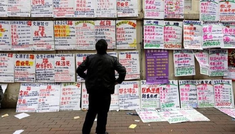 صيني يقرأ لافتات عليها معلومات عن وظائف ..رويترز