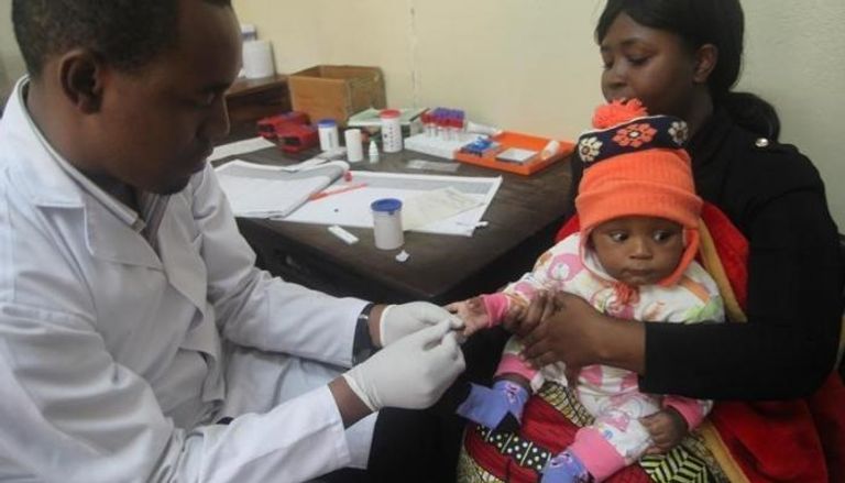 طبيب يكشف على طفل يعاني من الملاريا