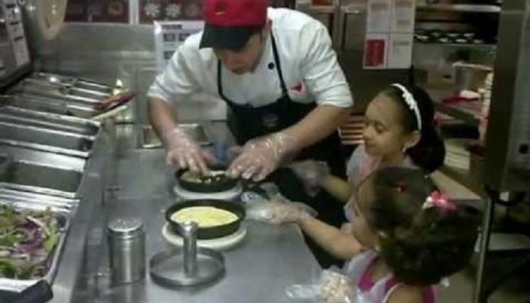 أطفال يشاركون في صنع البيتزا بأحد المحال