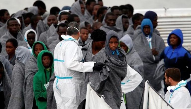 مهاجرون ينزلون من سفينة خفر سواحل إيطالية في ميناء كاتانيا في صقلية