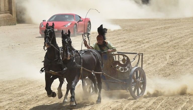 سيارة فيراري تسابق عربة يجرها جوادان