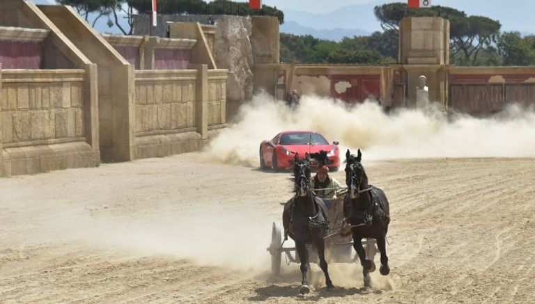 سيارة فيراري تسابق عربة يجرها جوادان