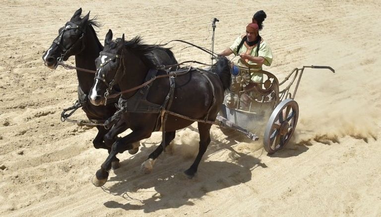 سيارة فيراري تسابق عربة يجرها جوادان