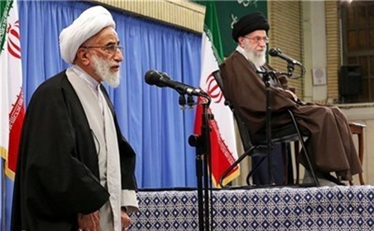 أمين مجلس صيانة الدستور أحمد جنتي خلال تقديم تقرير لخامنئي صورة خامنئي على آلية عسكرية (الفرنسية)