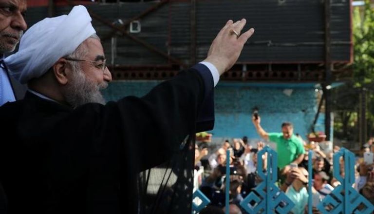 روحاني يلوح لأنصاره عند مركز اقتراع