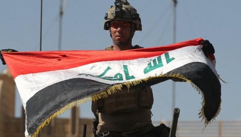 جندي عراقي يرفع علم البلاد في الموصل (الفرنسية)