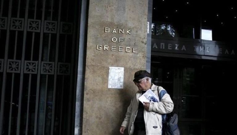 رجل يمر أمام البنك المركزي اليوناني في أثينا