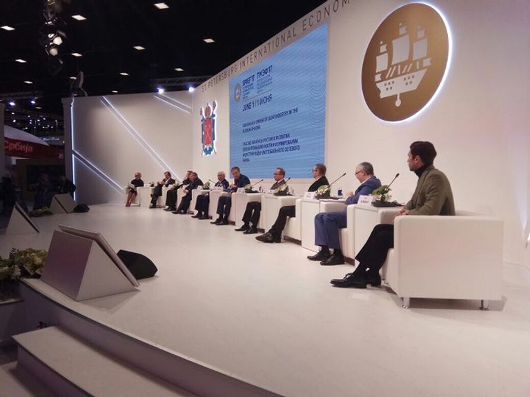 سيدة تتحدث في الهاتف أمام شعار المنتدى