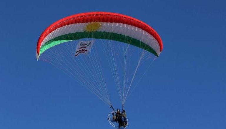 عراقي كردي يطير بمظلة على شكل علم كردستان (الفرنسية)