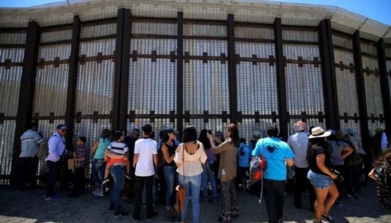 عائلات تتجمع على طول السياج الحدودي بين أمريكا والمكسيك 