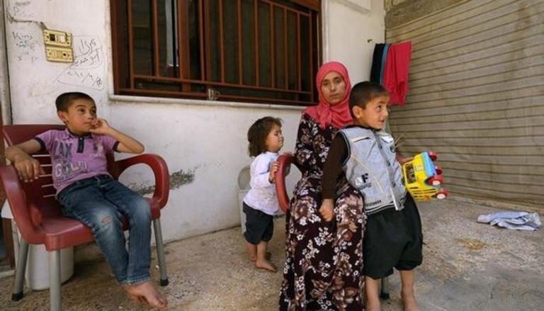 امرأة إيزيدية مع أطفالها حررهم مقاتلون أكراد  - رويترز