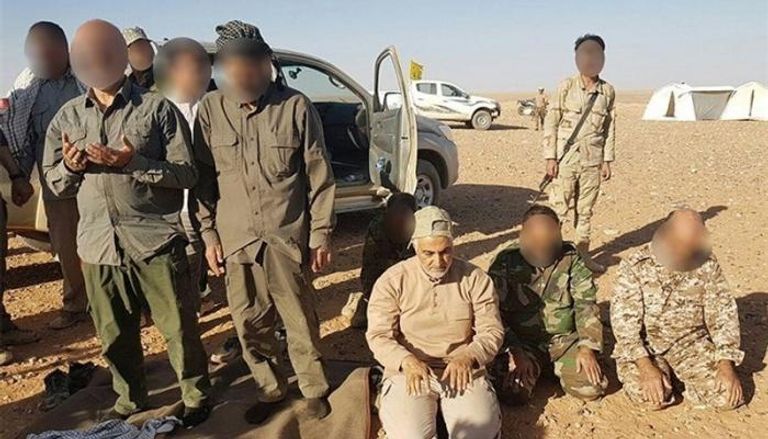 سليماني يصلي مع لواء فاطميون الأفغاني على حدود سوريا والعراق صورة خامنئي على آلية عسكرية (الفرنسية)