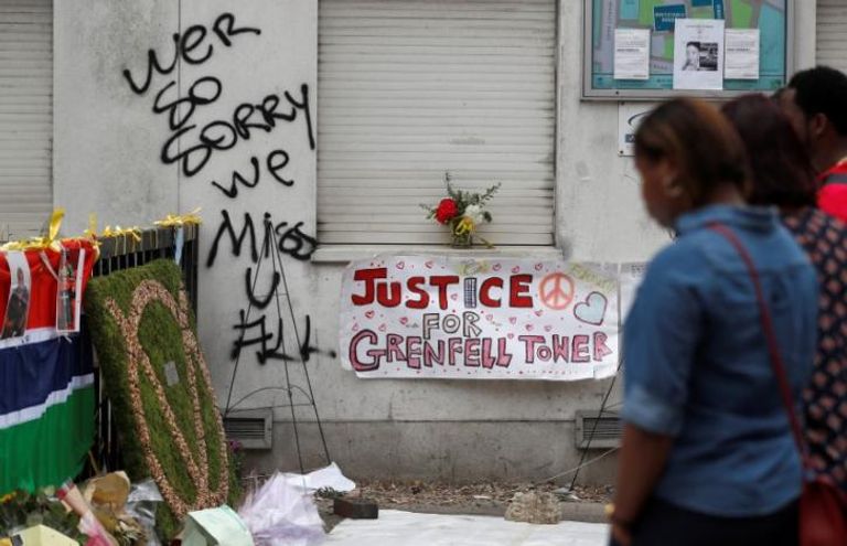 أشخاص يحملون ممتلكاتهم وهم يغادرون أحد الأبراج