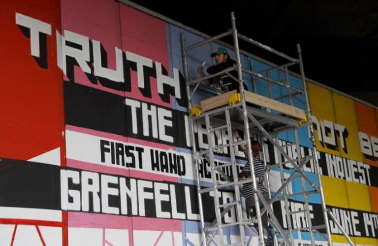 أشخاص يحملون ممتلكاتهم وهم يغادرون أحد الأبراج