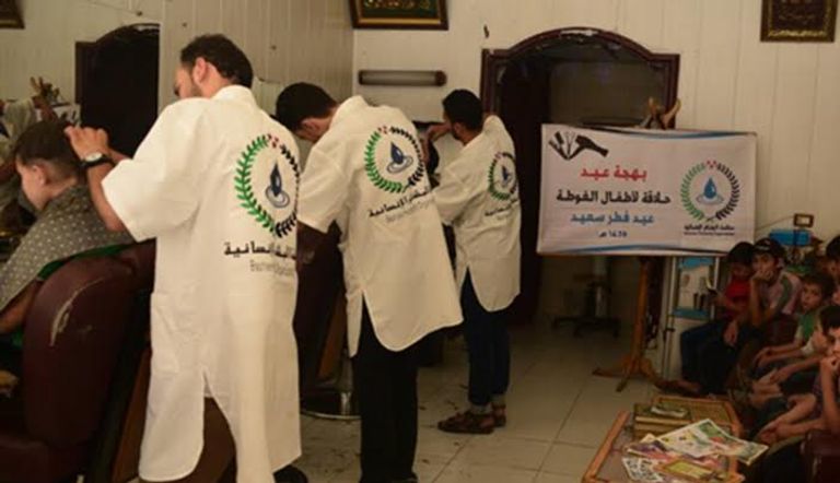 الأطفال ينتظرون دورهم في الحلاقة المجانية