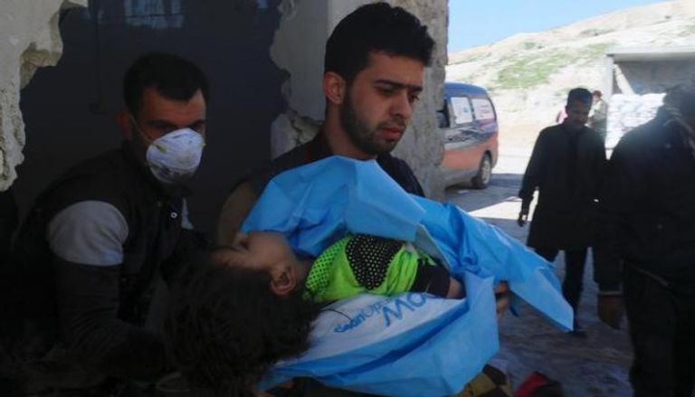 مسعف يحمل جثة طفلة قتلت بالغاز في خان شيخون