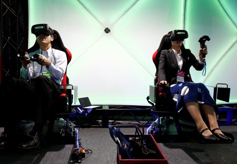أحد المشاركين بخوذة وقفازات خاصة بالواقع الافتراضي (رويترز)