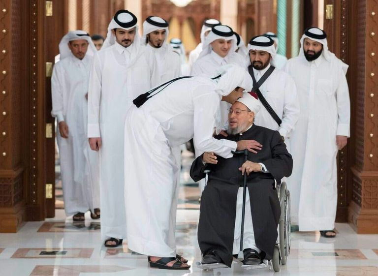 القرضاوي وسط مناصريه من تنظيم الإخوان الإرهابي (رويترز)