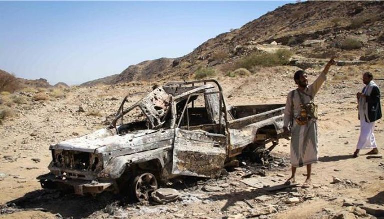 يمني إلى يقف إلى جوار شاحنة محترقة إثر قصف - أرشيف