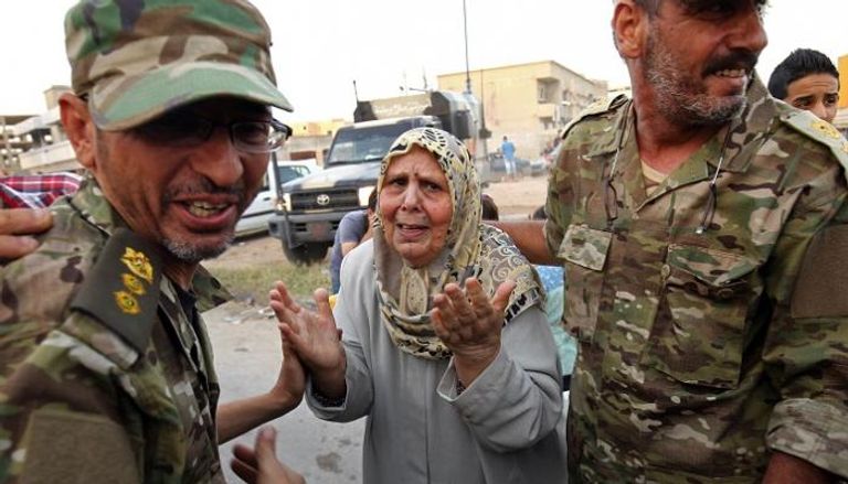سيدة تحتفل من أفراد الجيش الليبي بعد تحرير بنغازي - الفرنسية
