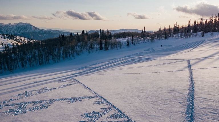 سيمون بيكر مع أحد أعماله الفنية على الثلج