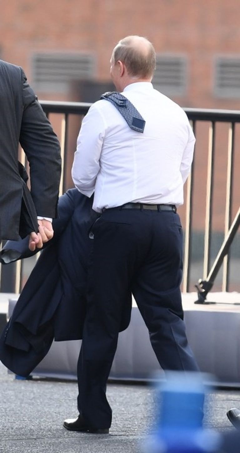 بوتين يتخفف من بعض ملابسه عقب وصوله إلى ألمانيا